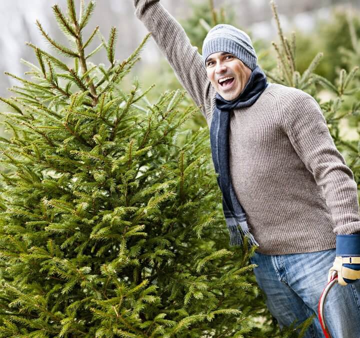 picture of man next to a Christmas tree (or xmas tree)